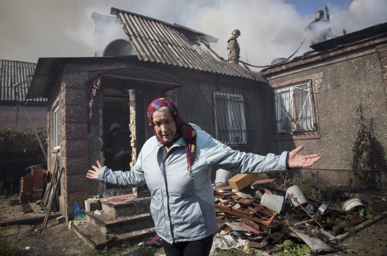 Nina Anatolyevna gestures in front of her burned private house after shelling in the town of Donetsk, eastern Ukraine Sunday, Oct. 5, 2014. (AP Photo/Dmitry Lovetsky)
