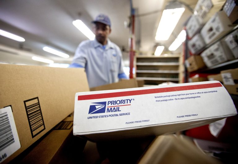 Packages wait to be sorted by a U.S. Postal Service employee. (AP/David Goldman)