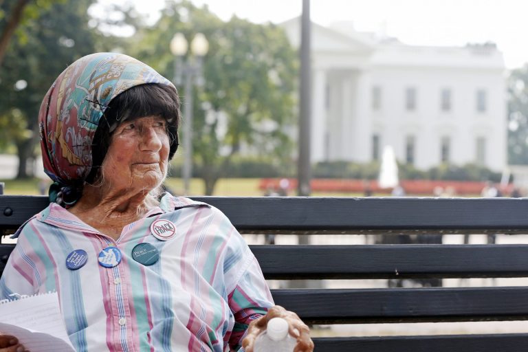   Protester Concepcion Picciotto, who holds a constant peace vigil in Lafayette Park across from the White House in Washington, sits on a park bench after her protest shelter was removed by Park Police, Thursday, Sept. 12, 2013. Picciotto, who held a peace vigil outside the White House since 1981, is up and running again after being dismantled for the first time in more than 30 years. (AP Photo/Charles Dharapak)  