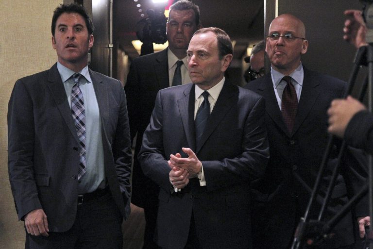   NHL commissioner Gary Bettman, center, arrives to speak with reporters after an NHL Board of Governors meeting, Wednesday, Dec. 5, 2012 in New York. The NHL and NHL Players' Association have cleared their schedules with progress being made in collective bargaining talks. (AP Photo/Mary Altaffer)  