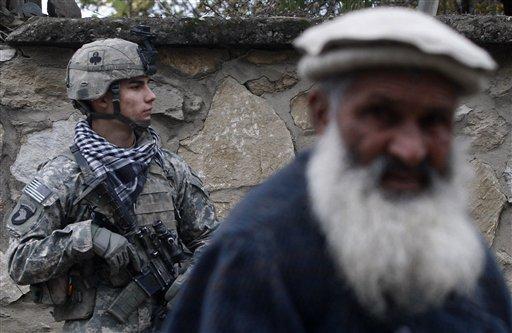 FILE - In this Dec. 30, 2010 file photo, U.S. Pfc. Nikolai Starr from San Antonio, Texas, of 2nd Platoon Bravo Company 2-327 stands guard as an Afghan man passes by during a patrol in Chowkay district, near the Pakistan border, Kunar province, eastern Afghanistan. (AP Photo/Rafiq Maqbool, File)
