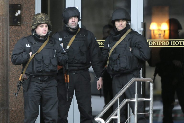 Riot police officers guard entrance in the Hotel Dnipro in Kiev, Ukraine, Tuesday, April 1, 2014. A tense standoff between Ukrainian police and a radical nationalist group Right Sector ended Tuesday, when its members surrendered their weapons and left a downtown hotel. Their departure followed a shooting spree in the capital, in which a Right Sector member shot and wounded three people outside a restaurant adjacent to the capital's main Independence Square, including a deputy mayor of the capital. (AP Photo/Efrem Lukatsky)