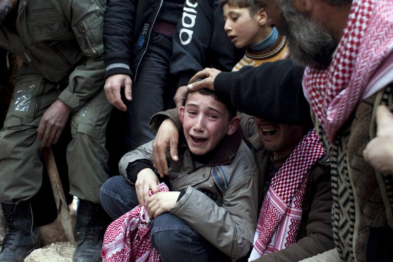 FILE - In this Thursday, March 8, 2012 file photo, Ahmed, center, mourns his father Abdulaziz Abu Ahmed Khrer, who was killed by a Syrian Army sniper, during his funeral in Idlib, north Syria. Syria's uprising was not destined to be quick. Instead, the largely peaceful protest movement that spread across the nation slowly turned into an armed insurgency and eventually a full-blown civil war. More than 130,000 people have been killed, and more than 2 million more have fled the country. (AP Photo/Rodrigo Abd, File)