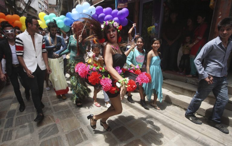 A participant poses as hundreds of lesbians, gays, bisexuals and transvestites parade through the streets during Gaijatra festival in Katmandu, Nepal, Monday, Aug. 11, 2014. The Hindu festival to remember the dead is gleefully overtaken each year by the country's gay community in this socially conservative Hindu-majority nation. (AP Photo/Bikram Rai)