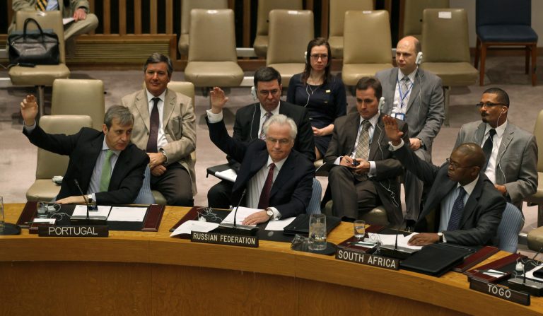 FILE - Members of the United Nations Security Council, including Russia's U.N. Ambassador Vitaly Churkin, foreground second from left, raise their hands in this April 14, 2012 file photo taken at U.N. headquarters. The U.N. Security Council faces a dramatic vote Thursday May 22, 2014 on referring the Syrian crisis to the International Criminal Court for investigation of possible war crimes, with dozens of countries signing on to embarrass Russia which vowed to kill the measure that demands a path to justice. (AP Photo/Craig Ruttle, File)