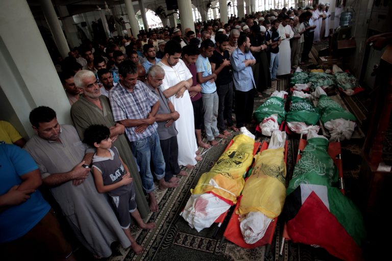 Palestinians mourners pray over the lifeless bodies of nine Palestinians killed in an early morning Israeli missile strike, at Bilal mosque during their funeral in the Khan Younis refugee camp, southern Gaza Strip, Saturday, July 19, 2014. Even as the death toll mounts in the Gaza Strip, attempts to broker a cease-fire between Hamas and Israel have so far run aground, in part because they have become mired in the deep schism between Mideast countries. (AP Photo/Khalil Hamra)