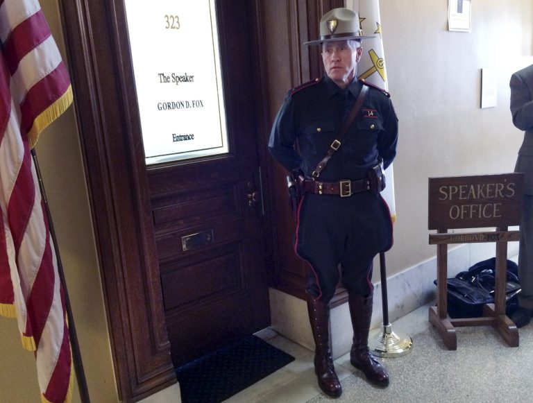A Rhode Island state trooper stands outside the office of House Speaker Gordon Fox on Friday at the Statehouse in Providence, R.I. (AP Photo/Erika Niedowski)