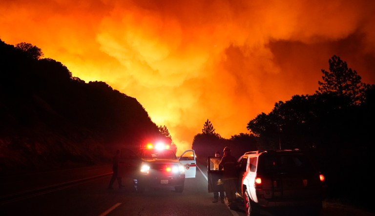 A fire official talks to members of the press at a check point as the Creek Fire advances along Highway 168 Tuesday, Sept. 8, 2020, near Alder Springs, Calif.