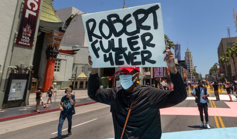A demonstrator carries a sign reading: "Robert Fuller 4Ever" during an All Black Lives Matter march organized by black members of the LGBTQ community, in the Hollywood section of Los Angeles on Sunday, June 14, 2020. Los Angeles County Sheriff Alex Villanueva will hold an online town hall Monday, June 15, to address the death of a black man found hanging from a tree in the city of Palmdale last week. Robert Fuller's body was discovered last Wednesday at a park near City Hall. 