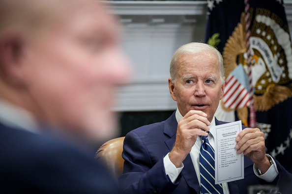 President Joe Biden holds up a cheat sheet during a meeting about the Federal-State Offshore Wind Implementation Partnership in the Roosevelt Room of the White House on Thursday in Washington.