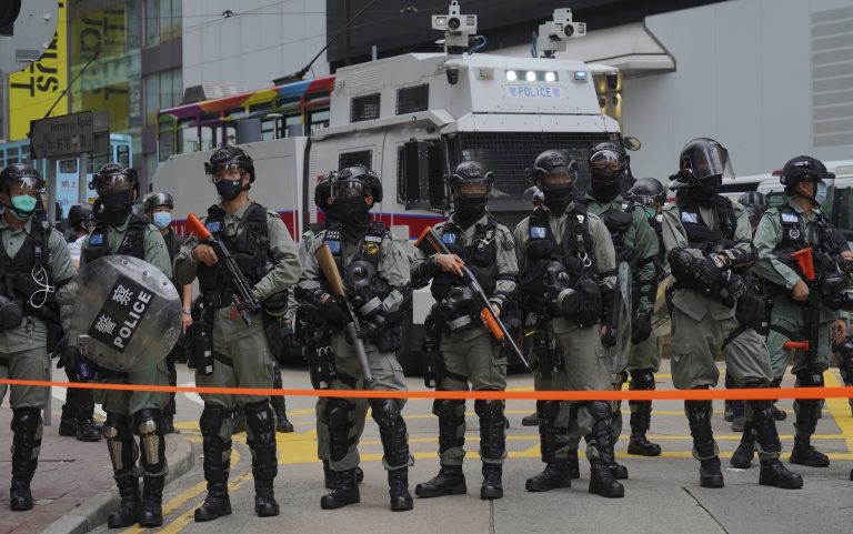 Riot Police stand in formation infront of water cannon tuck during a protest against Beijing's national security legislation in Causeway Bay in Hong Kong, Sunday, May 24, 2020. Hong Kong police fired volleys of tear gas in a popular shopping district as hundreds took to the streets Sunday to march against China's proposed tough national security legislation for the city.