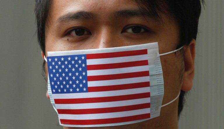 Hong Kong protestor wears an American flag mask over his face.