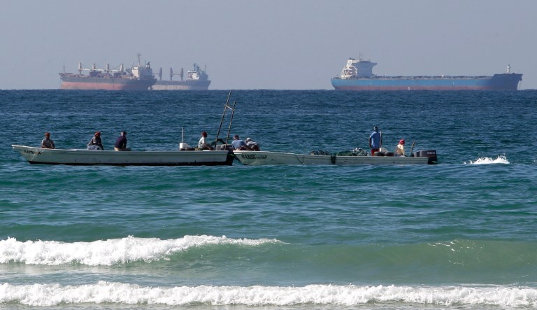 FILE - In this Jan. 19, 2012 file photo, fishing boats are seen in front of oil tankers on the Persian Gulf waters, south of the Strait of Hormuz, offshore the town of Ras Al Khaimah in United Arab Emirates. The European Union has announced plans to join US efforts to slow the flow of oil from Iran, the world's third largest exporter. In response, Iran has threatened to shut the Strait of Hormuz and prevent one fifth of the world's oil from reaching customers. 