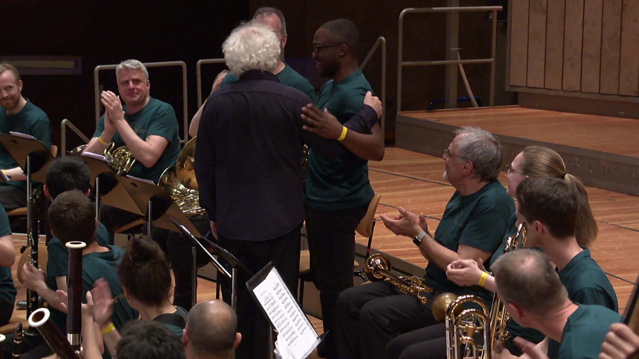 Simon Rattle puts his arm around American French horn player Cody Lidge during a BE PHIL rehearsal.
