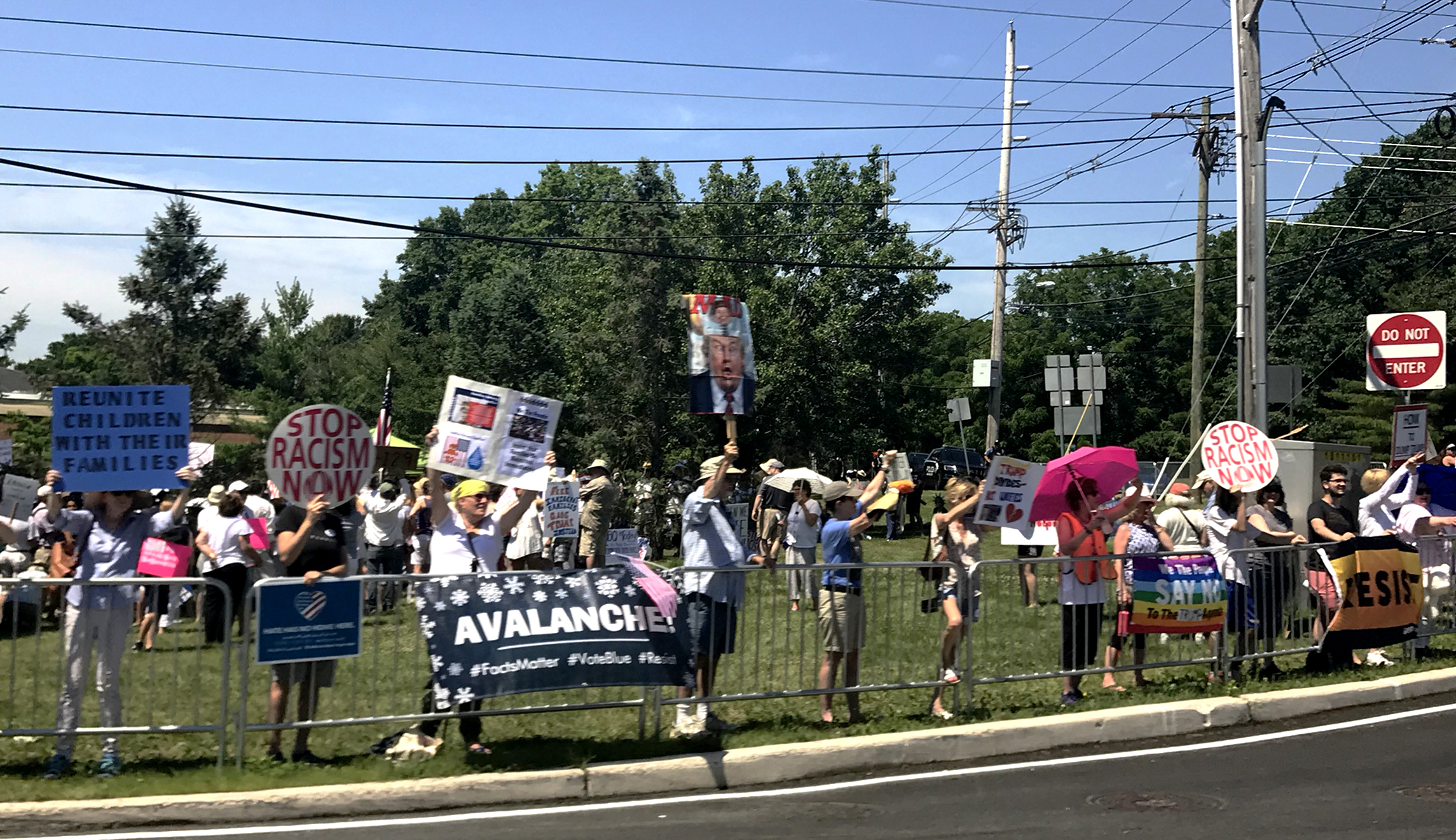 Protesters hold signs against President Trump's immigration policy in Bedminster, N.J.
