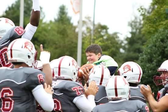 Maryville College Football team hoists Seth Cate on their shoulders after he scored a touchdown during a scrimmage before a game a couple of years ago. Seth has Duchenne Muscular Dystrophy (DMD) and is part of the Coach to Cure MD effort across college football games Saturday to raise awareness and help fund critical research grants.