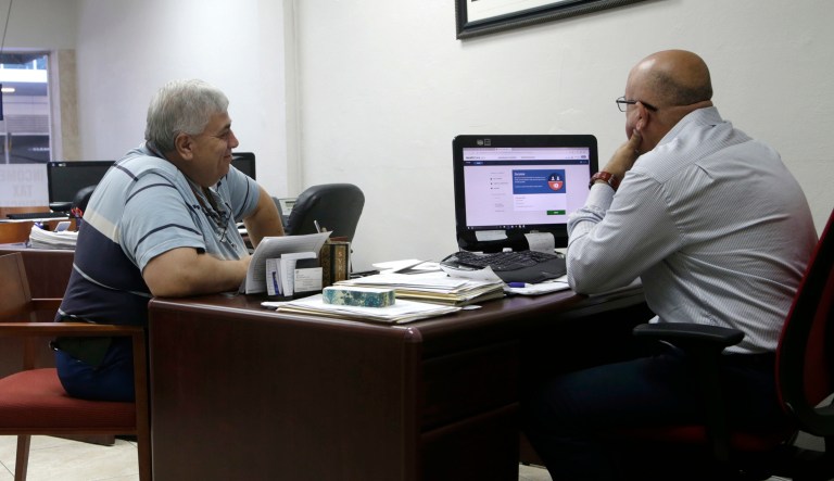 Sami Jamaleddine, left, signs up for health insurance offered under the Affordable Care Act with insurance agent Michael Khoury, right, Tuesday, Jan. 31, 2017, in Miami. The enrollment period for the federal health care law known as "Obamacare" ends at the end of the day Tuesday. The Republican-lead Senate has passed a measure to take the first step forward on dismantling President Barack Obama's health care law.