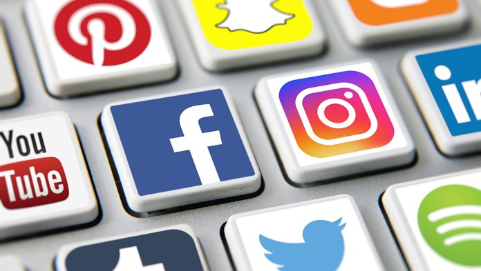Social media icons printed and placed on computer keyboard applications Facebook, Twitter, Instagram, Youtube, Pinterest, Snapchat etc.