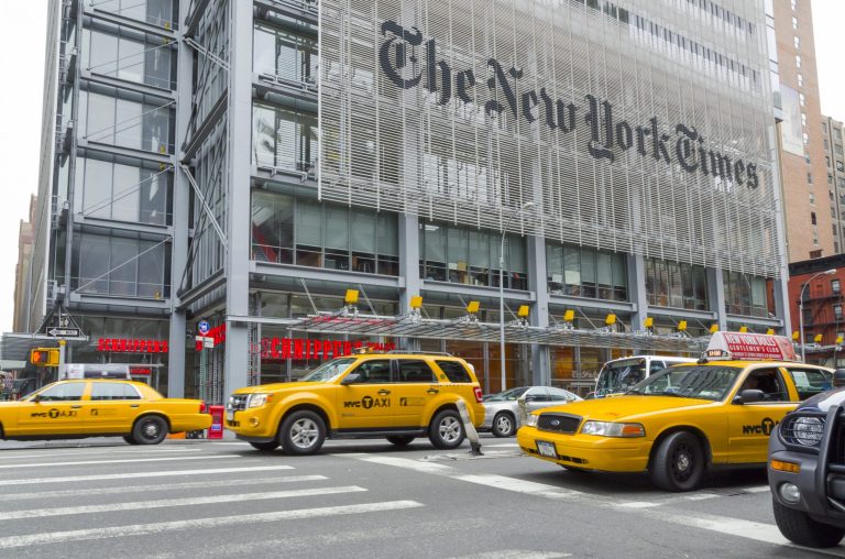 New York City, April 22, 2012: Three yellow cabs pass in front of the New York Times headquarters in New York as the street light turns to green.