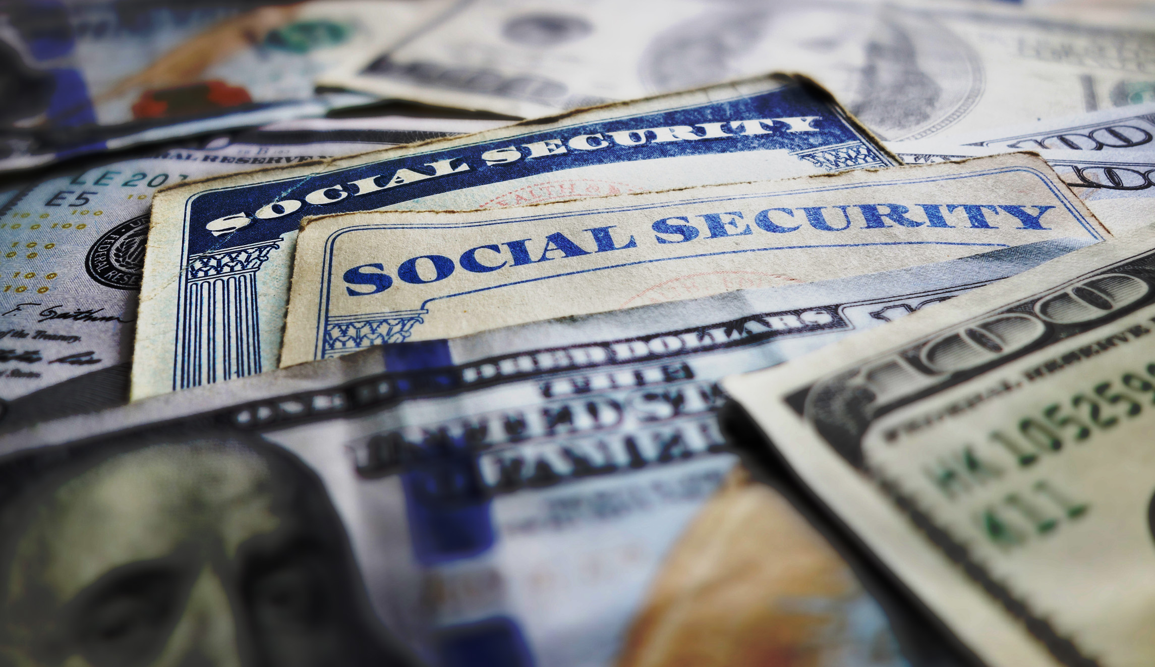 A stock photo is shown with old Social Security cards and $100 bills.