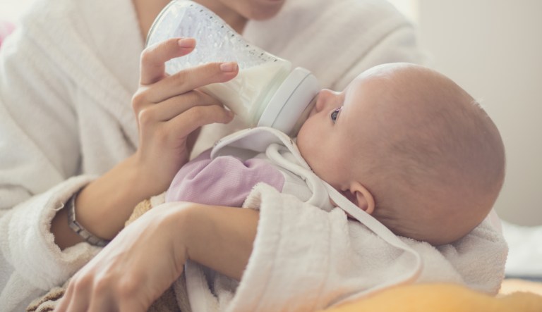 Mother feeding her little baby from the milkbottle