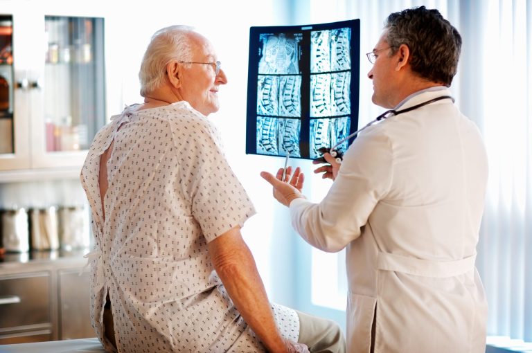 Senior man discussing X-ray with doctor.