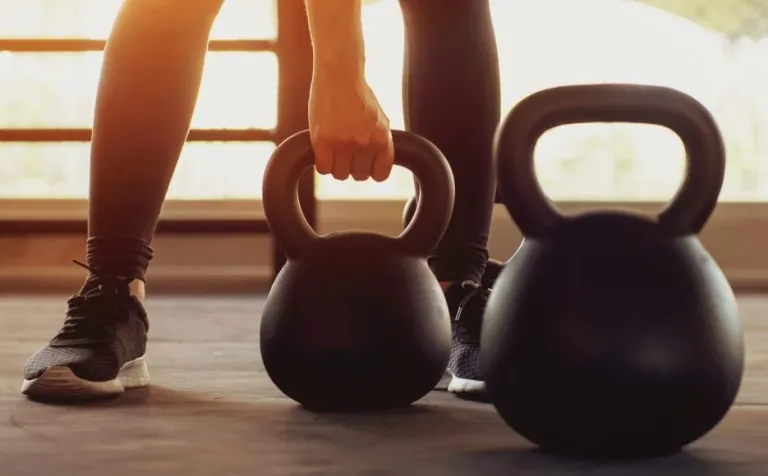 A person trains with a kettlebell in a gym.