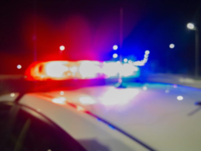 Red and blue lights of police car in night time. Night patrolling the city. Abstract blurry image.