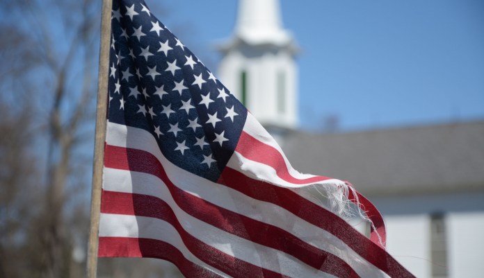 An American flag is seen near a church.