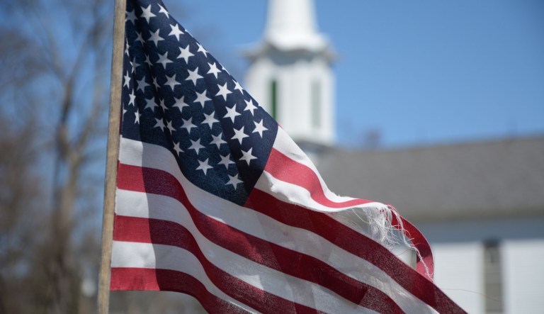 An American flag is seen near a church.