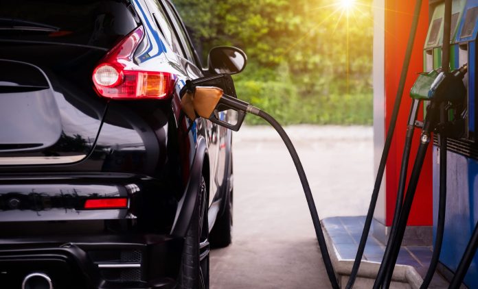 Pumping gasoline into a car.