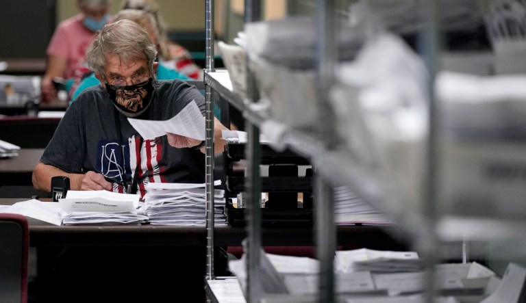 Election worker Kenneth Conkle processes mail-in ballot requests, Tuesday, Sept. 22, 2020, at the Johnson County election office in Olathe, Kan. The office has processed more than 100,000 mail-in ballot requests so far as more people than normal are expected to vote by mail due to concerns about the new coronavirus. (AP Photo/Charlie Riedel)                 
