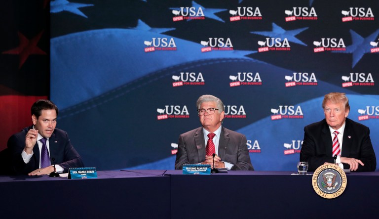Sen. Marco Rubio, R-Fla., left, makes a statement in Spanish as he sits with Sunshine Gasoline Distributors, Inc., president Maximo Alvarez, center, and President Donald Trump, at a roundtable discussion on tax cuts for Florida small businesses, in Hialeah, Fla.