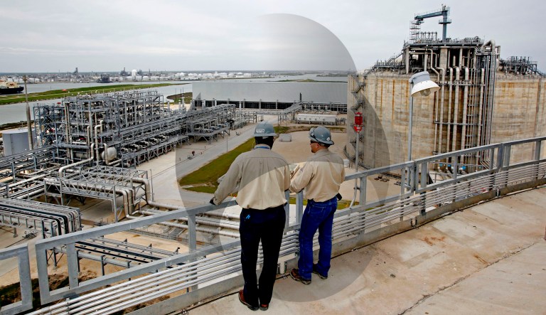 Two people are shown at the Freeport LNG facility in Quintana, Texas. A model of a methane molecule is pictured in the background.