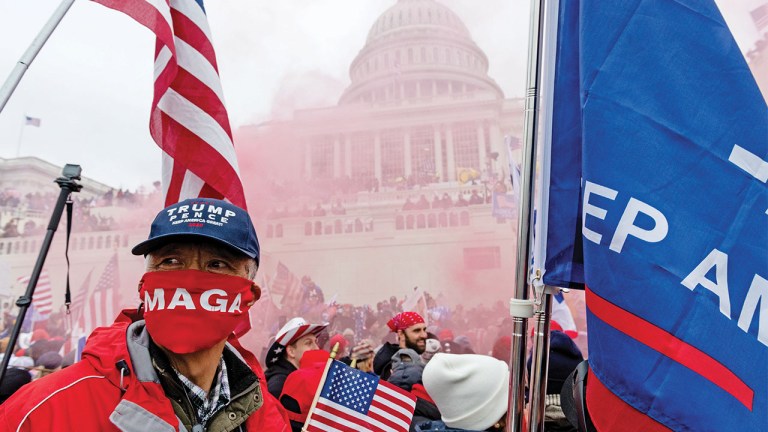A protester unleashes a smoke grenade in front of the U.S. Capitol building during a protest in Washington on Jan. 6.