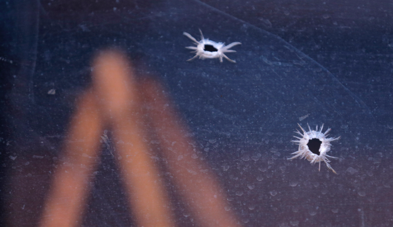 Bullet holes are seen in the window of the Sacred Heart School, across the street from a kosher supermarket, in Jersey City, N.J., Wednesday, Dec. 11, 2019. Jersey City Mayor Steven Fulop said authorities believe gunmen targeted the market during a shooting that killed multiple people Tuesday. (AP Photo/Seth Wenig)