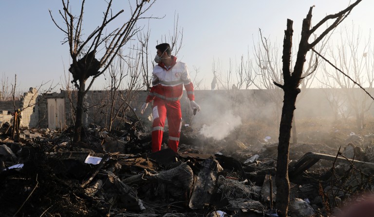 A rescue worker searchs the scene where an Ukrainian plane crashed in Shahedshahr southwest of the capital Tehran, Iran, Wednesday, Jan. 8, 2020. A Ukrainian airplane carrying 176 people crashed on Wednesday shortly after takeoff from Tehran's main airport, killing all onboard. 