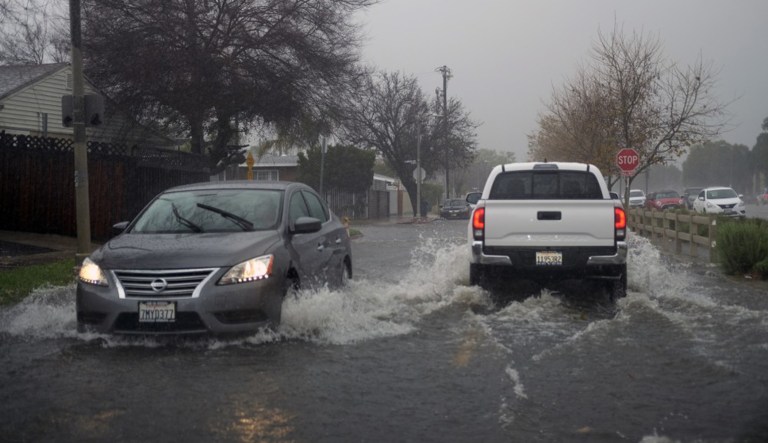 Vehicles make their way through flooded streets of Panorama City section of the San Fernando Valley in Los Angeles on Saturday.