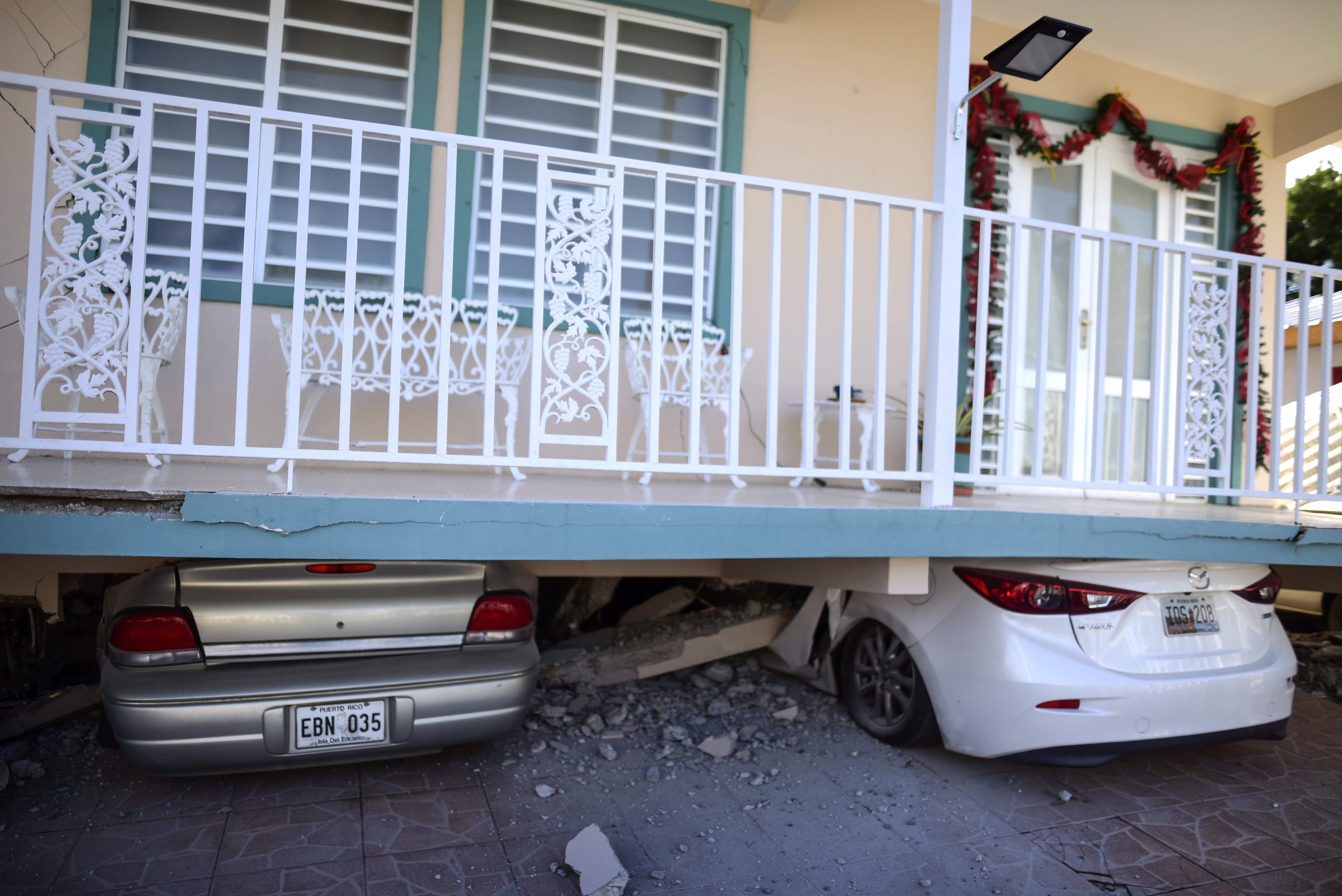 Cars crushed under the weight of collapsed home