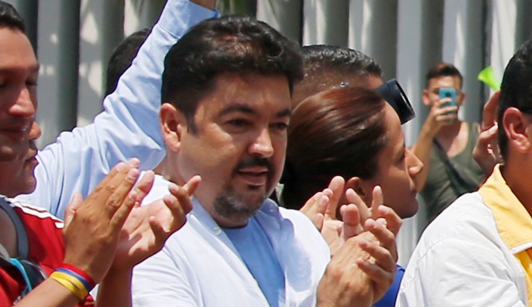 In this Saturday, March 16, 2019 photo, lawyer Roberto Marrero, center, applauds upon his arrival to a rally of Venezuelan opposition leader Juan Guaido, who has declared himself interim president in Valencia, Venezuela.