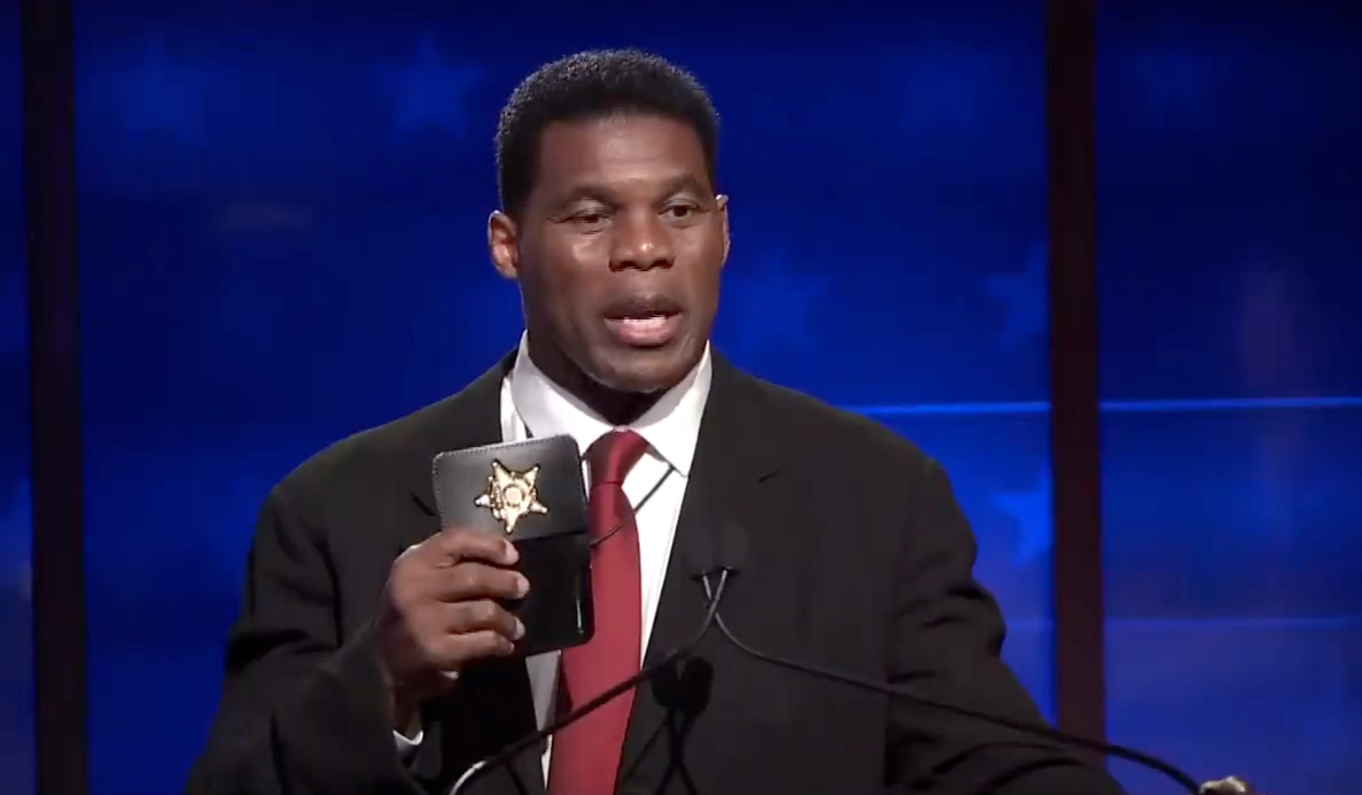 WATCH: Herschel Walker flashes prop badge onstage during debate with Warnock
