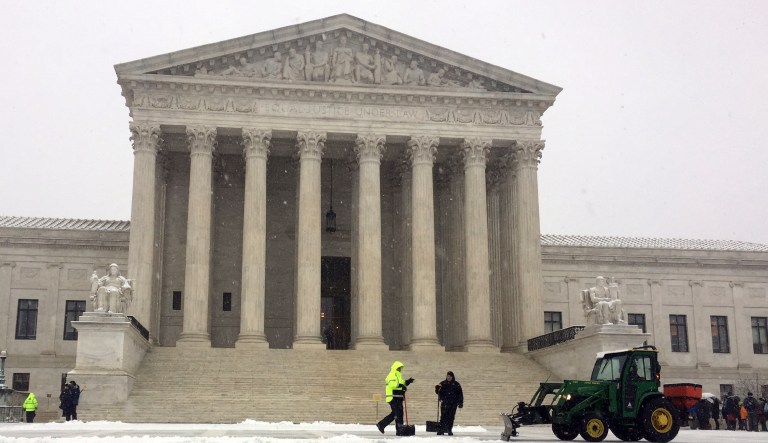 Crews remove early morning snow during a winter storm at the Supreme Court, Wednesday, Feb. 20, 2019 in Washington.
