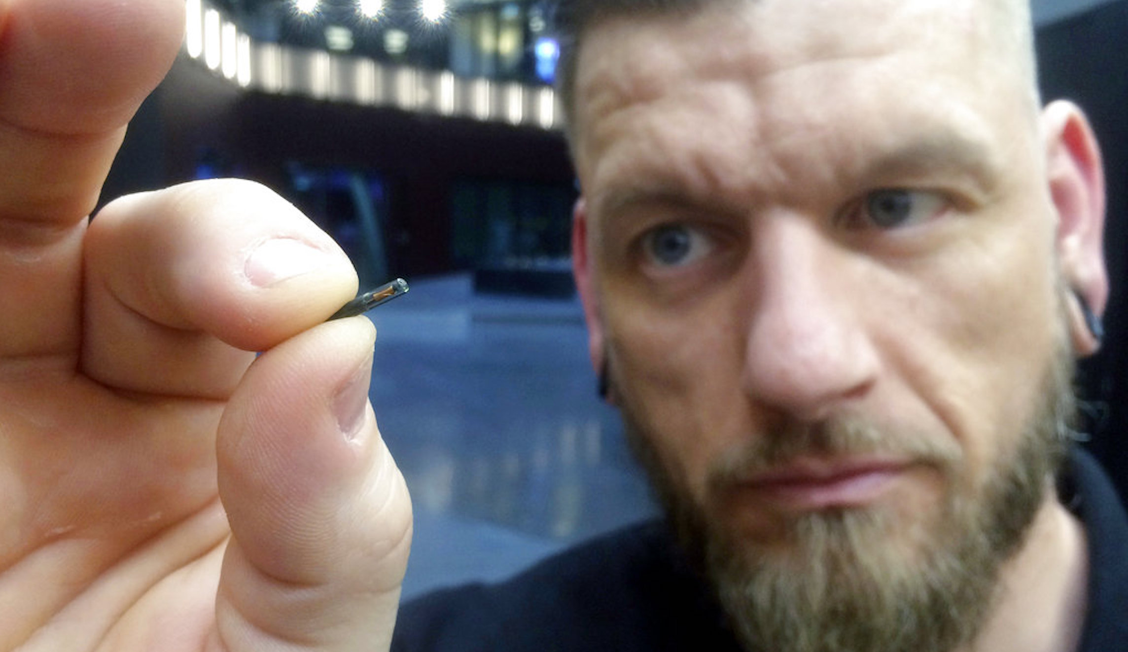 In this March 14, 2017, file photo, Jowan Osterlund from Biohax Sweden, holds a small microchip implant, similar to those implanted into workers at the Epicenter digital innovation business centre during a party at the co-working space in central Stockholm.