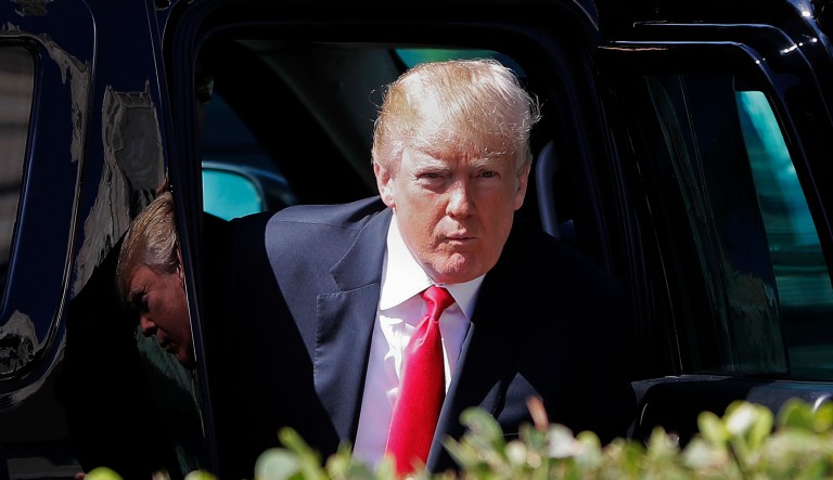 President Donald Trump steps out of his armored SUV as he arrives for Easter services at Episcopal Church of Bethesda-by-the-Sea, in Palm Beach, Fla., Sunday, April 1, 2018.