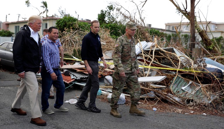 President Donald Trump walks with FEMA administrator Brock Long, second from right, and Lt. Gen. Jeff Buchanan, right as he tours an area affected by Hurricane Maria in Guaynabo, Puerto Rico, Tuesday, Oct. 3, 2017. Trump is visiting Puerto Rico in the wake of Hurricane Maria.