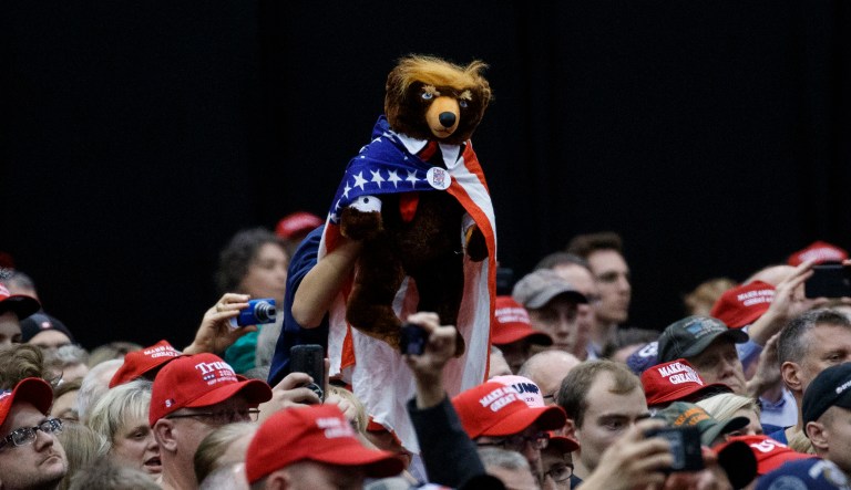 A supporter of President Donald Trump holds up a bear as the president speaks during a rally, at the IX Center, in Cleveland, Monday, Nov. 5, 2018.
