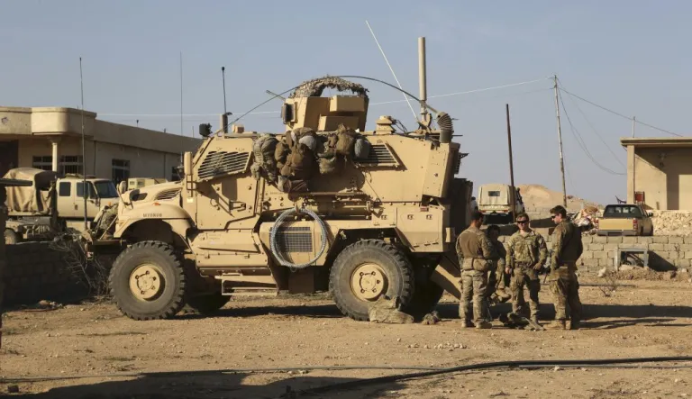 U.S. Army soldiers stand outside their armoured vehicle in a joint base with Iraqi army south of Mosul, Iraq, Thursday, Feb. 23, 2017.