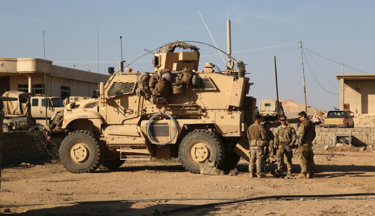 U.S. Army soldiers stand outside their armoured vehicle in a joint base with Iraqi army south of Mosul, Iraq, Thursday, Feb. 23, 2017.