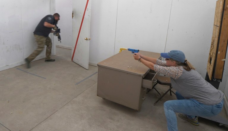 In this Saturday, June 29, 2019, photo, Christy Belt, Timpanogos Academy 5th grade teacher, engages in an exercise designed to help teachers make good decisions in critical, high stress situations such as an active shooter incident during the teacher's academy training at the Utah County Sheriff's Office shooting range, in Spanish Fork Canyon, Utah. About 30 teachers in Utah are spending their summer learning how to stuff wounds and shoot guns as part of a training held by police to prepare educators for an active shooter scenario in their schools.