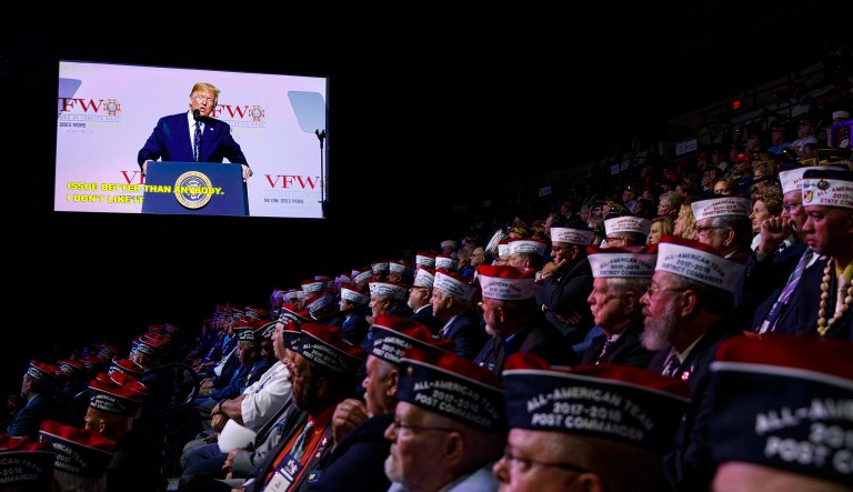 Audience members listen as President Donald Trump speaks during the Veterans of Foreign Wars of the United States National Convention Tuesday, July 24, 2018, in Kansas City, Mo.